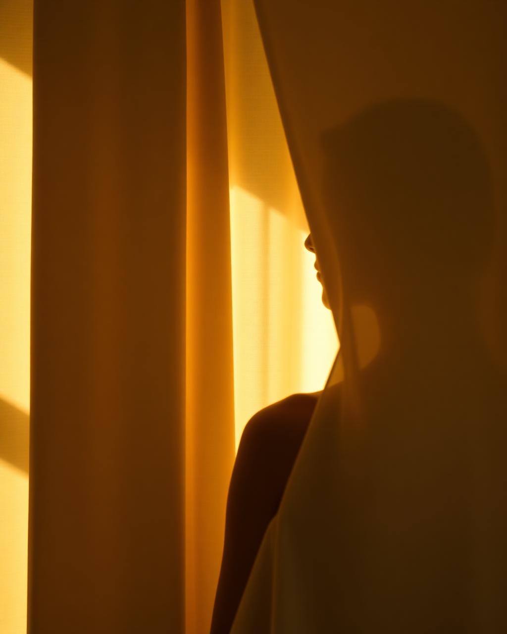 Soft golden light through ivory drapery at THEIA